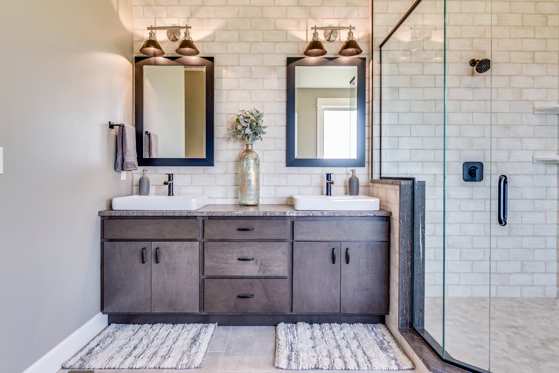 Double vanity bathroom with subway tile, glass shower and modern fixtures